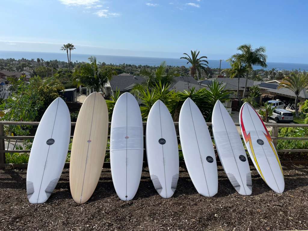 Row of hand-shaped boards with a California ocean view
